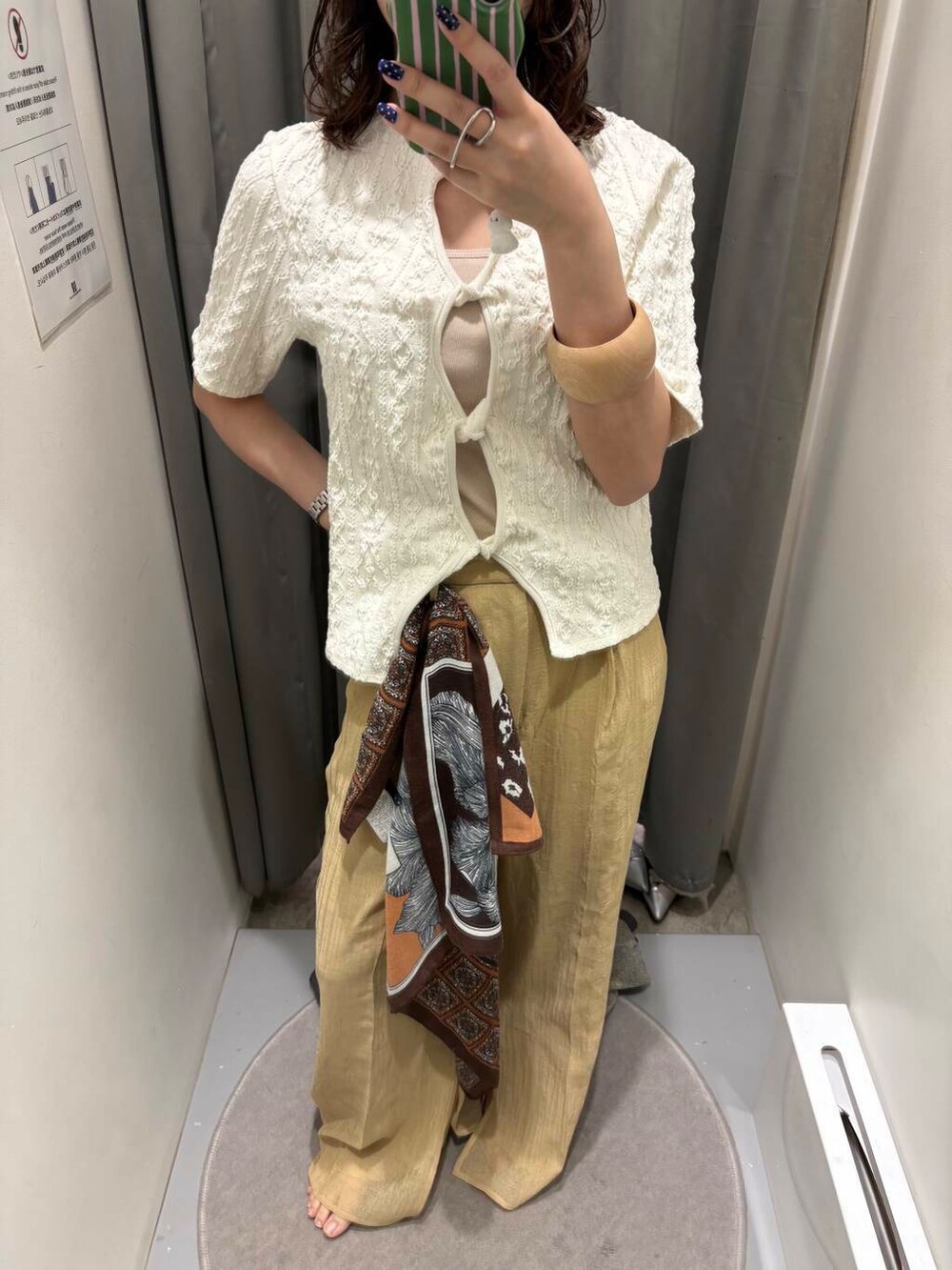 ベージュ系のキャミソール、ゴールド系のサンダル、ホワイト系のTシャツ/カットソーを着用したレディースの春コーディネートの4枚目の写真