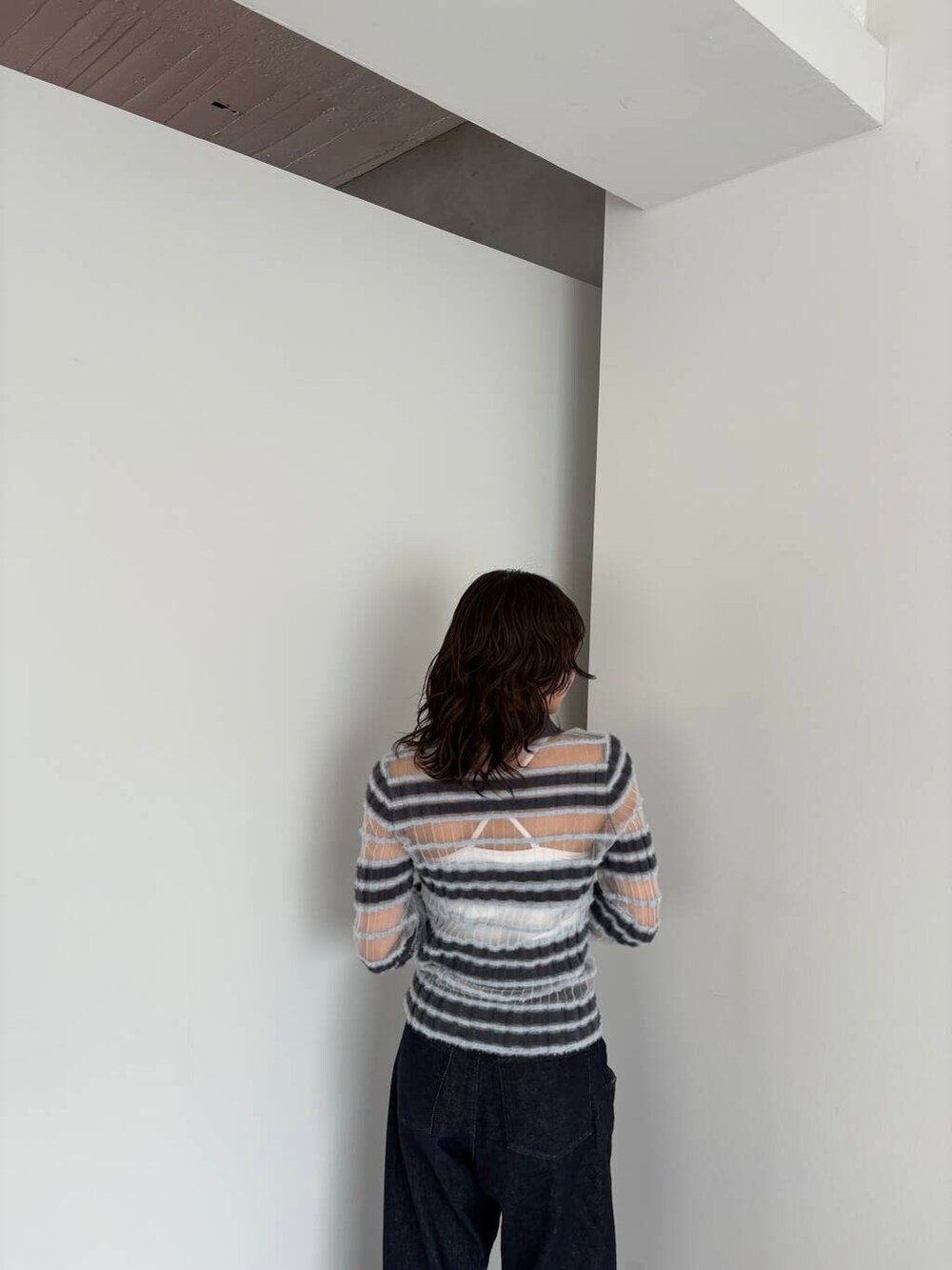 ブルー系のデニムパンツ、ブラック系のその他シューズ、グレー系のニット/セーターを着用したレディースの夏コーディネートの4枚目の写真