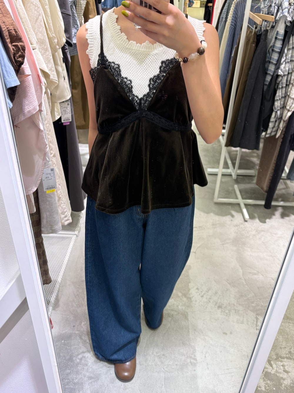 グリーン系のセットアップ、ブルー系のデニムパンツ、ブラウン系のサンダルを着用したレディースの秋コーディネートの3枚目の写真
