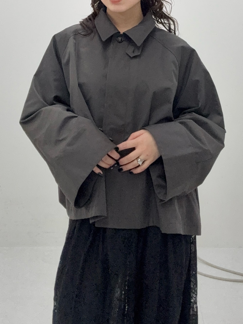 グレー系のステンカラーコート、ブラック系のその他パンツ、ブラック系のその他シューズを着用したレディースの冬コーディネートの4枚目の写真