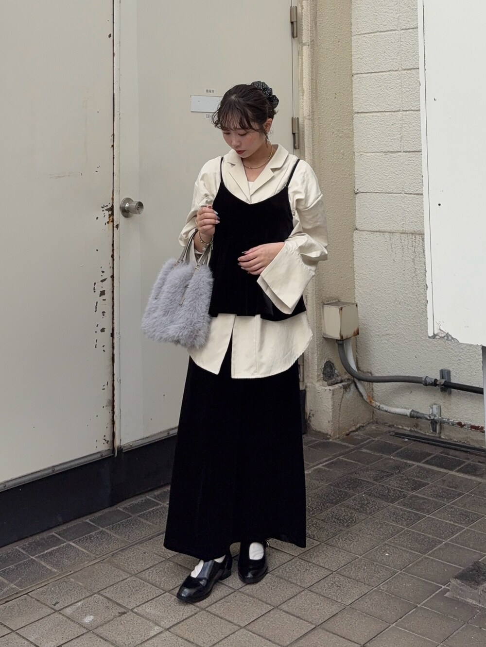 ブラック系のキャミソール、ブラック系のスカート、ホワイト系のシャツ/ブラウスを着用したレディースの秋コーディネートの2枚目の写真