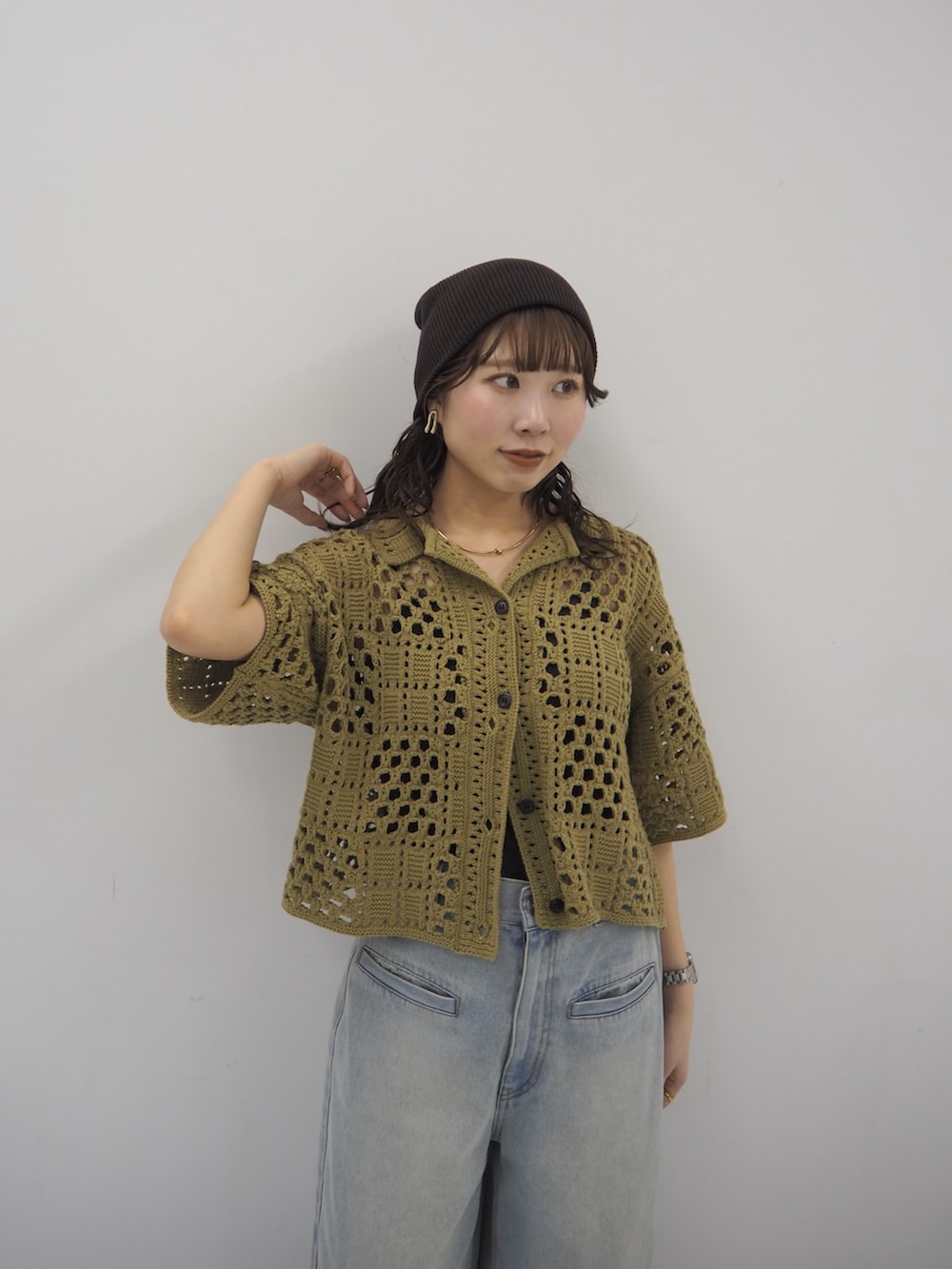 グリーン系のニット/セーター、ブラック系のその他シューズ、グレー系のニットキャップ/ビーニーを着用したレディースの春コーディネートの4枚目の写真