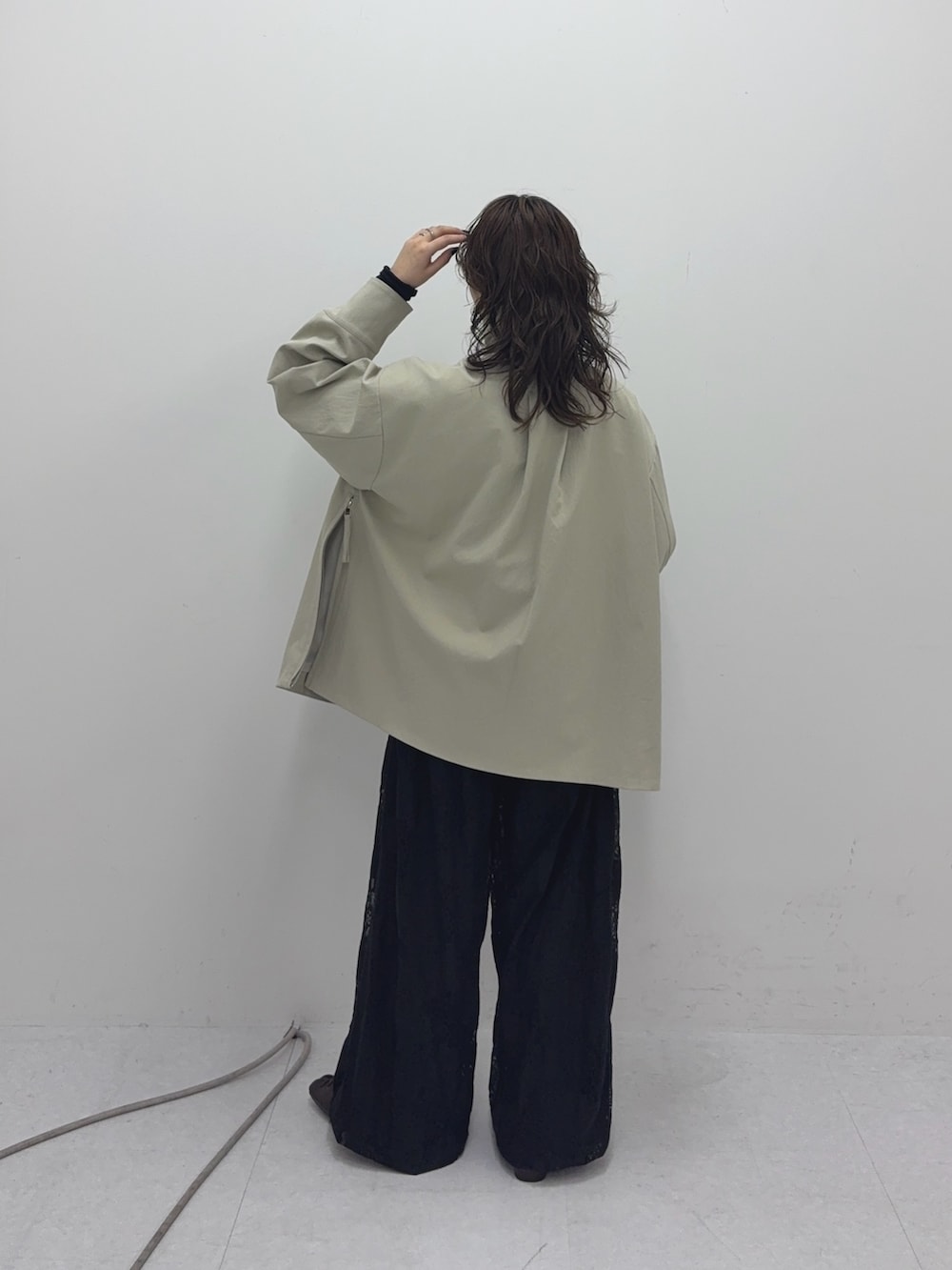 ベージュ系のその他アウター、ブラック系のその他パンツ、グリーン系のショルダーバッグを着用したレディースの冬コーディネートの3枚目の写真