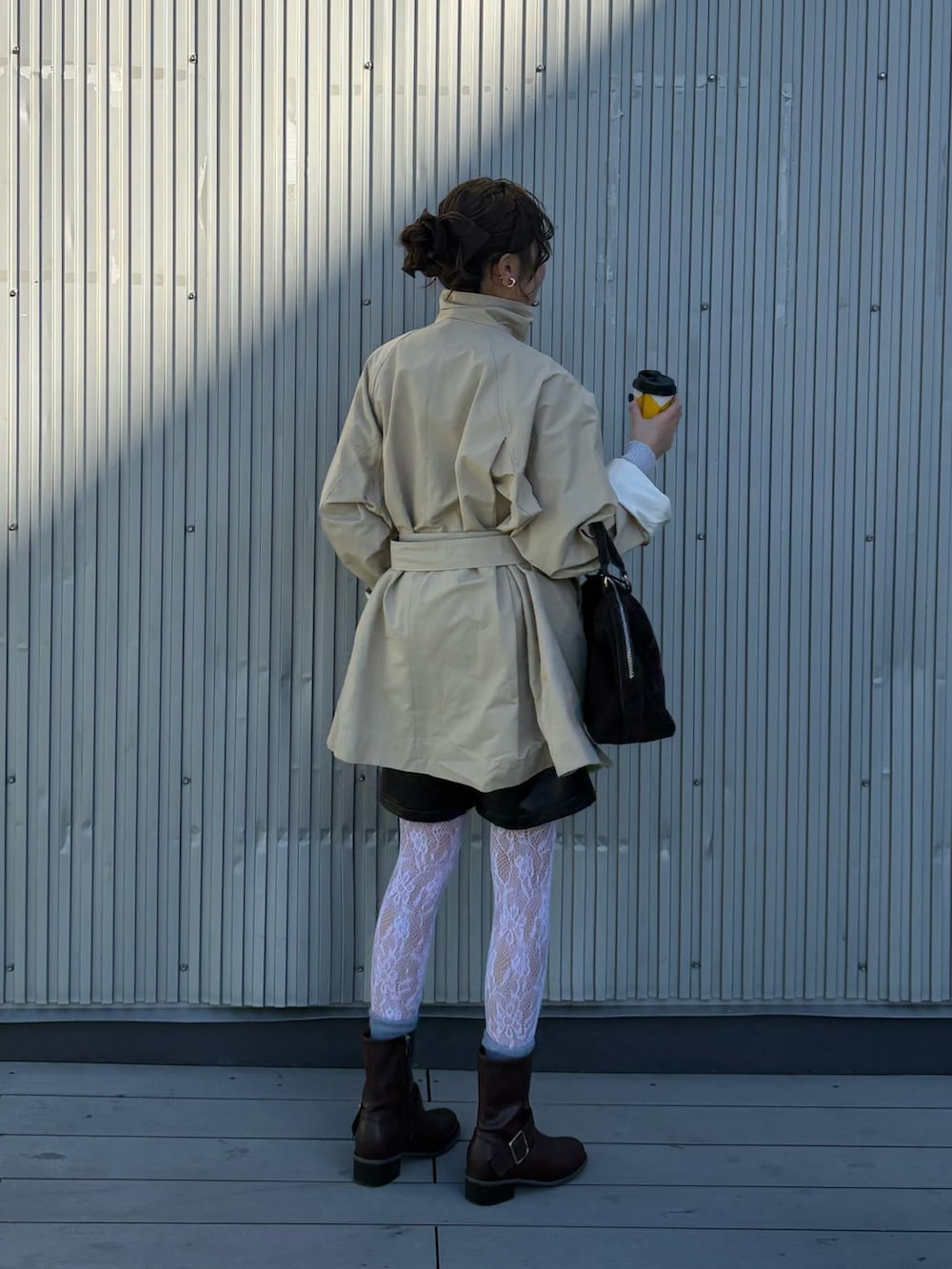 ベージュ系のその他アウター、ブラウン系のブーツ、ブラウン系のボストンバッグを着用したレディースの冬コーディネートの3枚目の写真