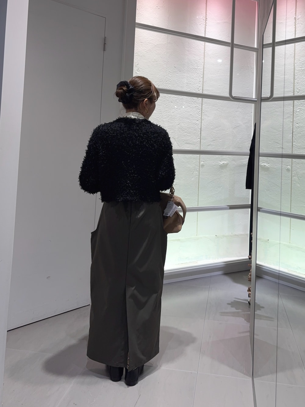 ホワイト系のTシャツ/カットソー、ブラック系のニット/セーター、ベージュ系のボストンバッグを着用したレディースの冬コーディネートの3枚目の写真