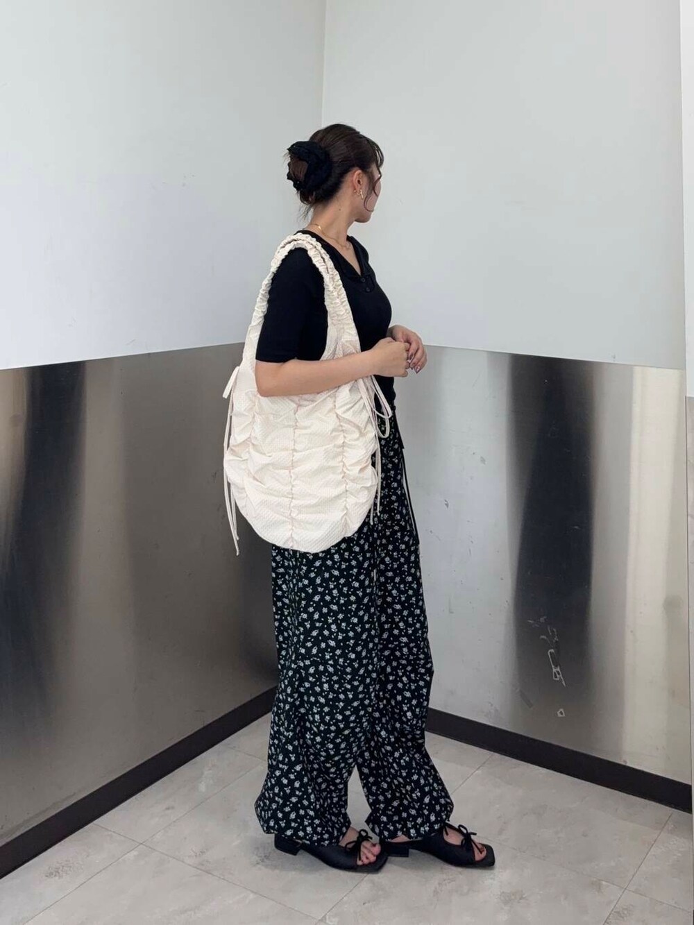 ブラック系のサンダル、ブラック系のその他パンツ、ホワイト系のショルダーバッグを着用したレディースの夏コーディネートの2枚目の写真