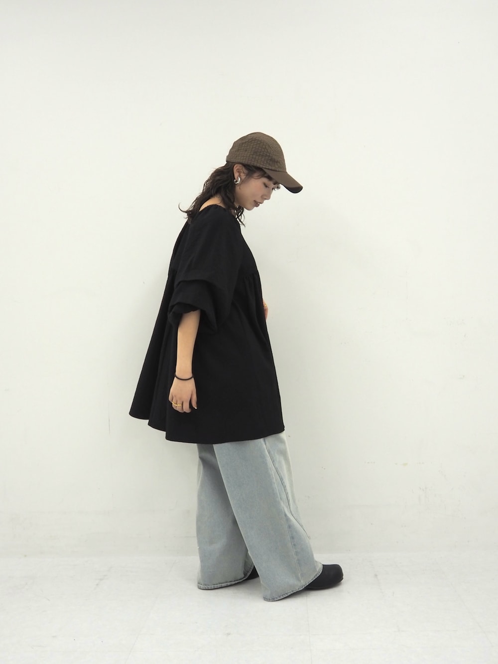 ブラック系のワンピース、ブルー系のデニムパンツ、ブラック系のその他シューズを着用したレディースの春コーディネートの3枚目の写真