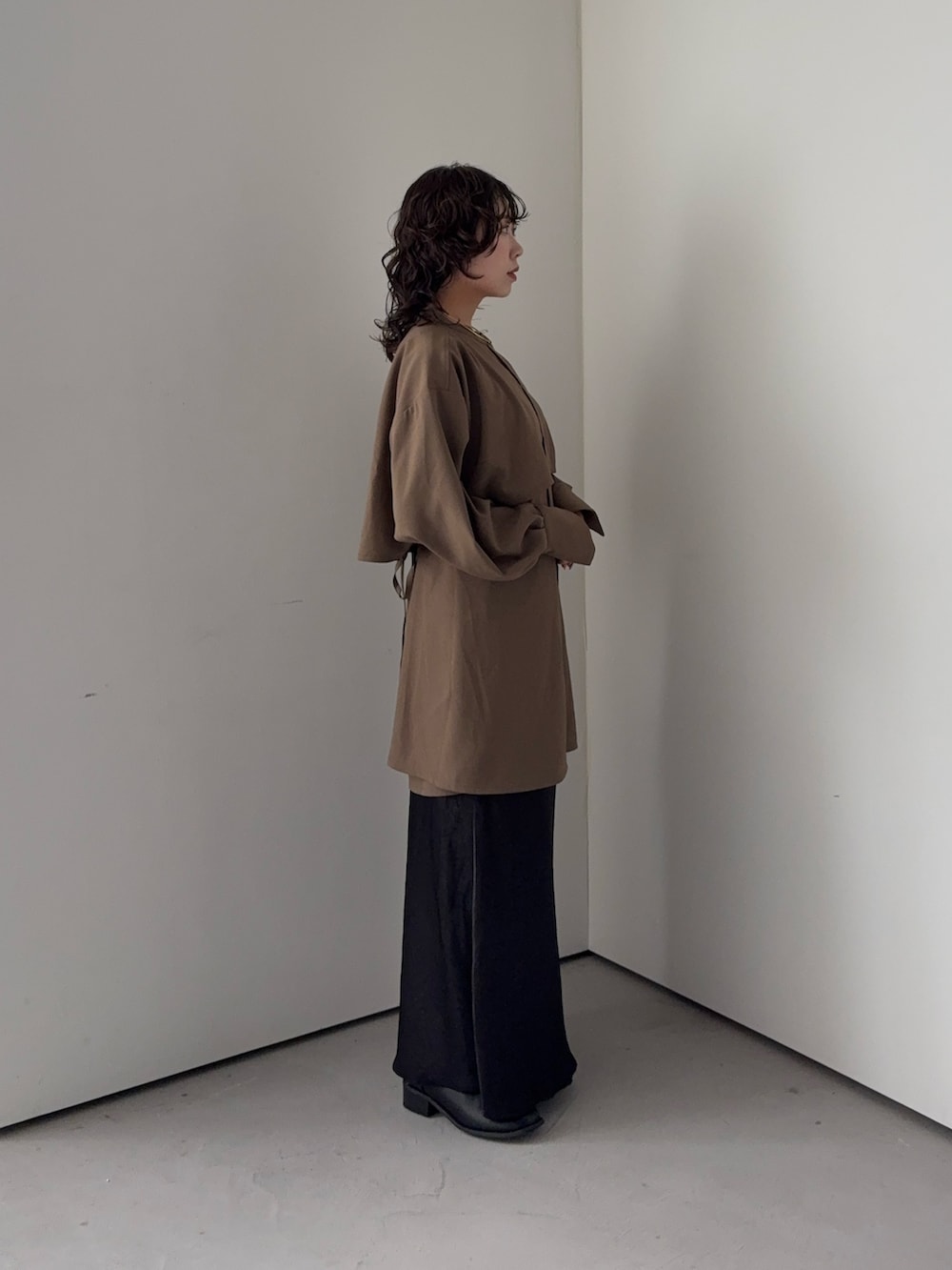 ブラウン系のワンピース、グレー系のスカートを着用したレディースの秋コーディネートの2枚目の写真