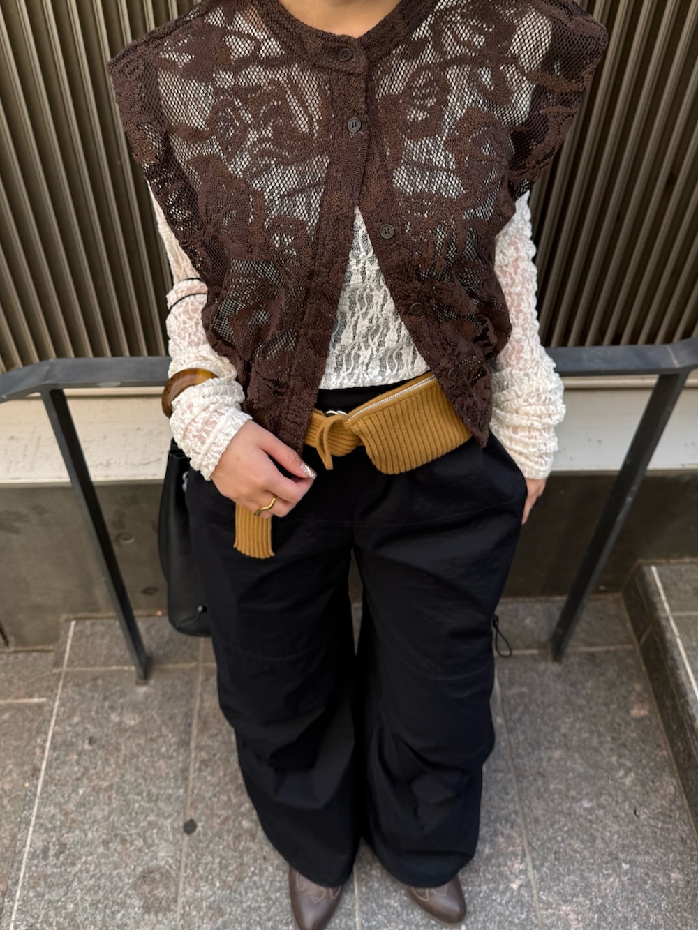ブラウン系のシャツ/ブラウス、ブラック系のハンドバッグ、ホワイト系のTシャツ/カットソーを着用したレディースの春コーディネートの4枚目の写真
