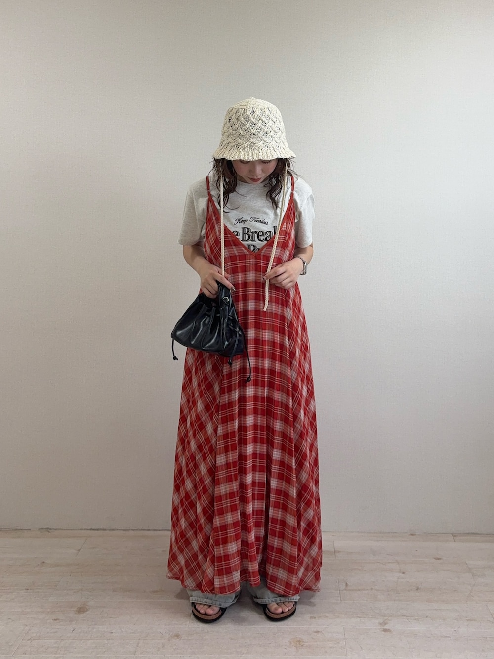レッド系のワンピース、ベージュ系のTシャツ/カットソー、ブルー系のデニムパンツを着用したレディースの夏コーディネートの3枚目の写真