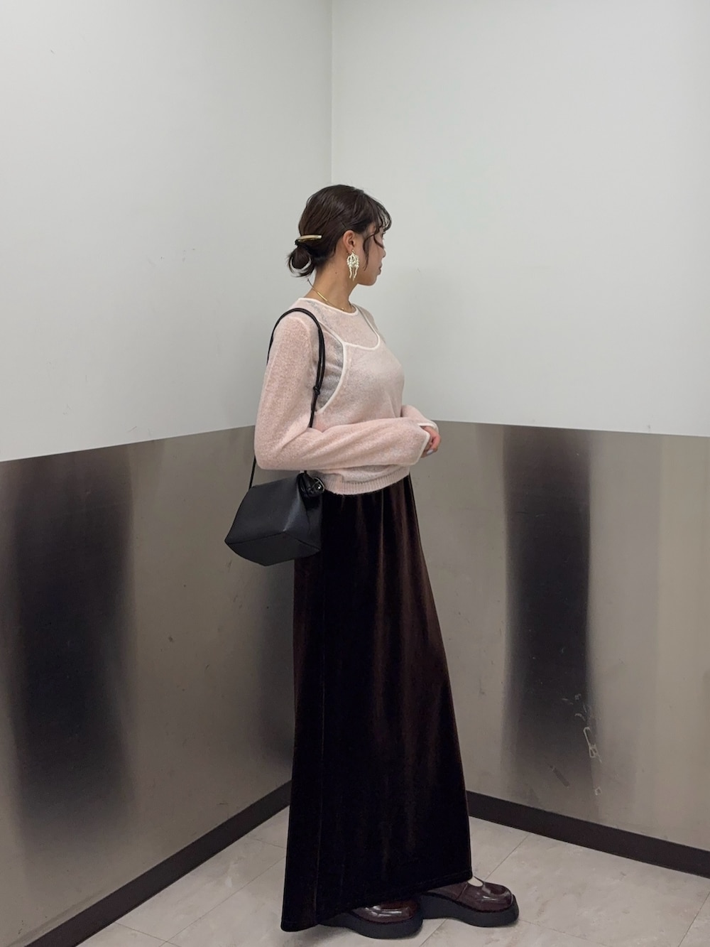 ブラウン系のスカート、ピンク系のニット/セーター、ブラック系のショルダーバッグを着用したレディースの秋コーディネートの2枚目の写真