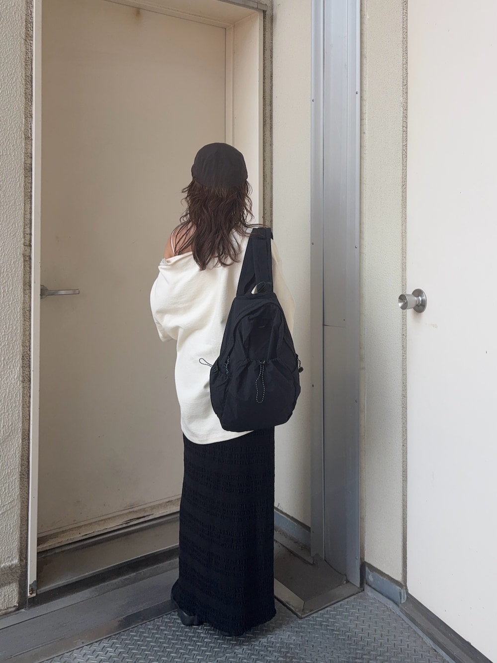 ホワイト系のTシャツ/カットソー、ブラック系のスカート、ブラック系のバックパック/リュックを着用したレディースの夏コーディネートの3枚目の写真