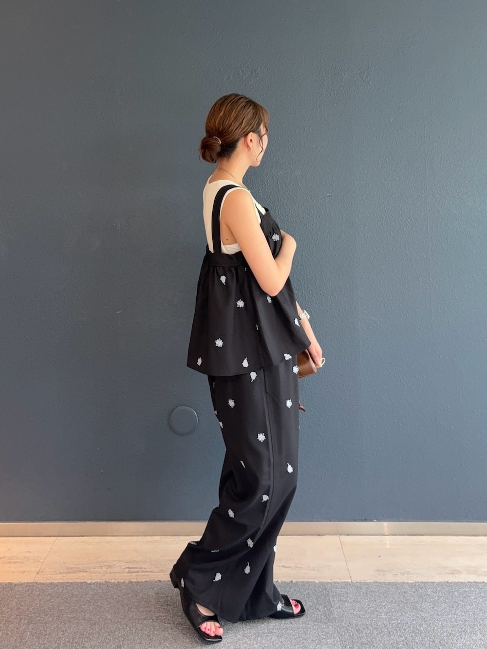 ブラック系のシャツ/ブラウス、ブラック系のその他パンツ、ブラウン系のハンドバッグを着用したレディースの夏コーディネートの2枚目の写真