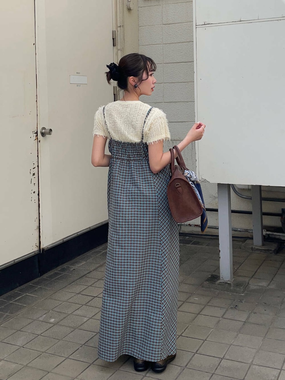 ブラウン系のボストンバッグ、グリーン系のスニーカー、ブルー系のワンピースを着用したレディースの春コーディネートの3枚目の写真