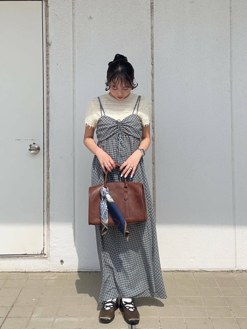 ブラウン系のボストンバッグ、グリーン系のスニーカー、ブルー系のワンピースを着用したレディースの春コーディネートの2枚目の写真