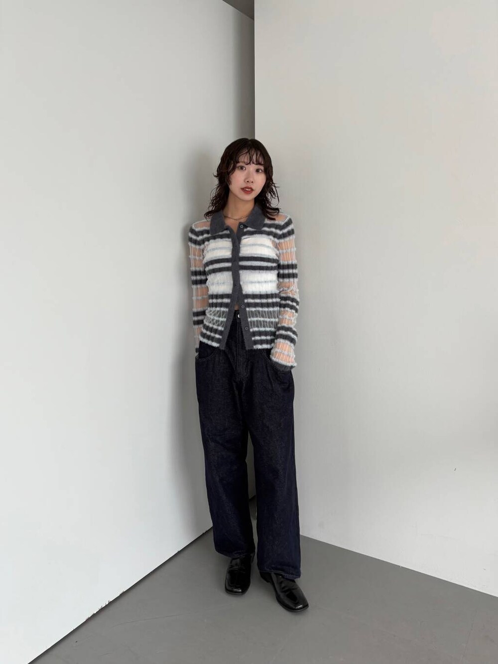 ブルー系のデニムパンツ、ブラック系のその他シューズ、グレー系のニット/セーターを着用したレディースの夏コーディネートの2枚目の写真