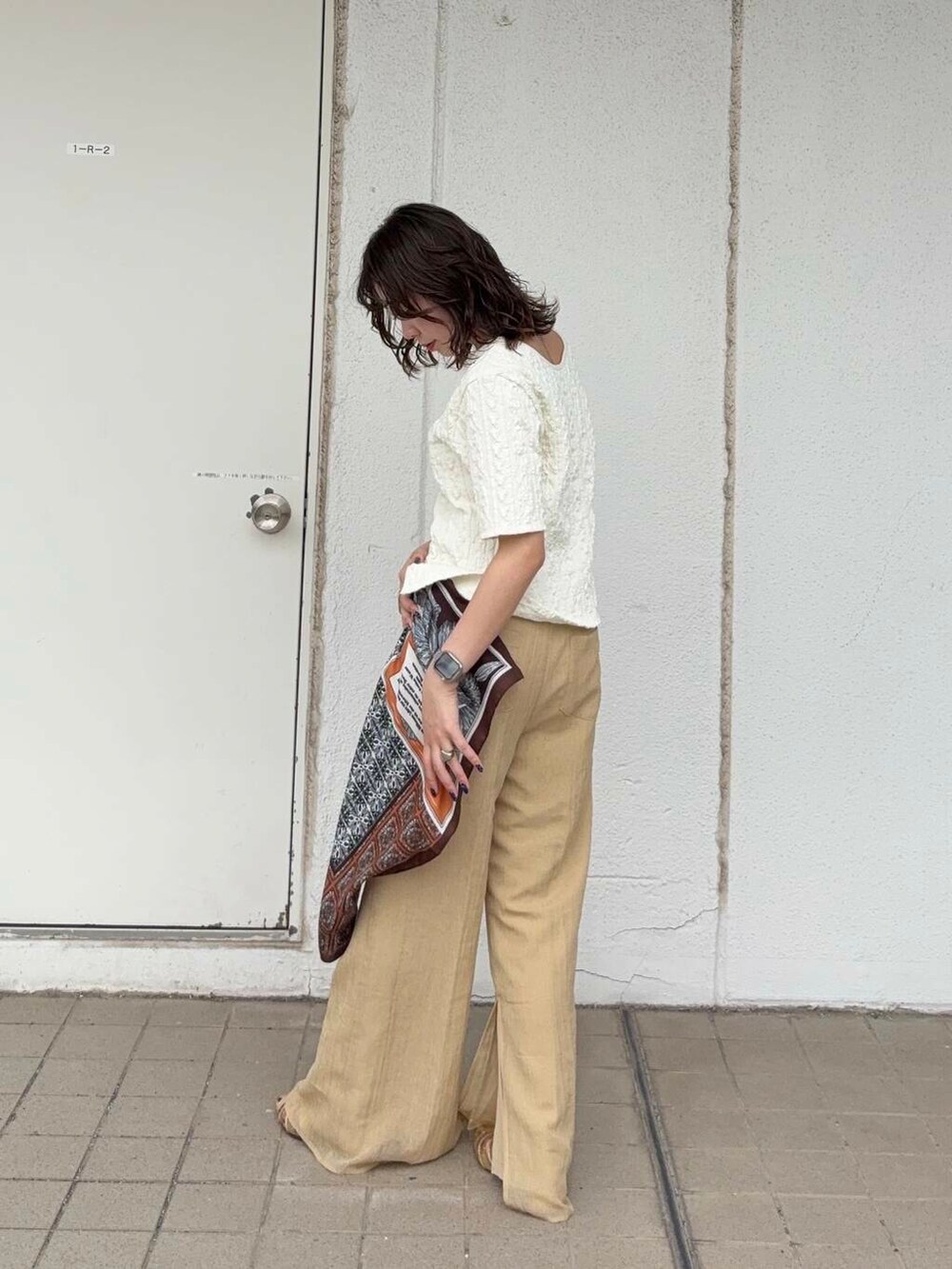 ベージュ系のキャミソール、ゴールド系のサンダル、ホワイト系のTシャツ/カットソーを着用したレディースの春コーディネートの3枚目の写真