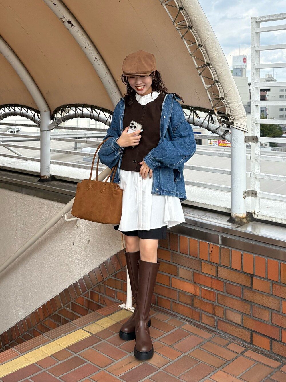 ホワイト系のワンピース、ブラウン系のその他アウター、イエロー系のボストンバッグを着用したレディースの秋コーディネートの3枚目の写真