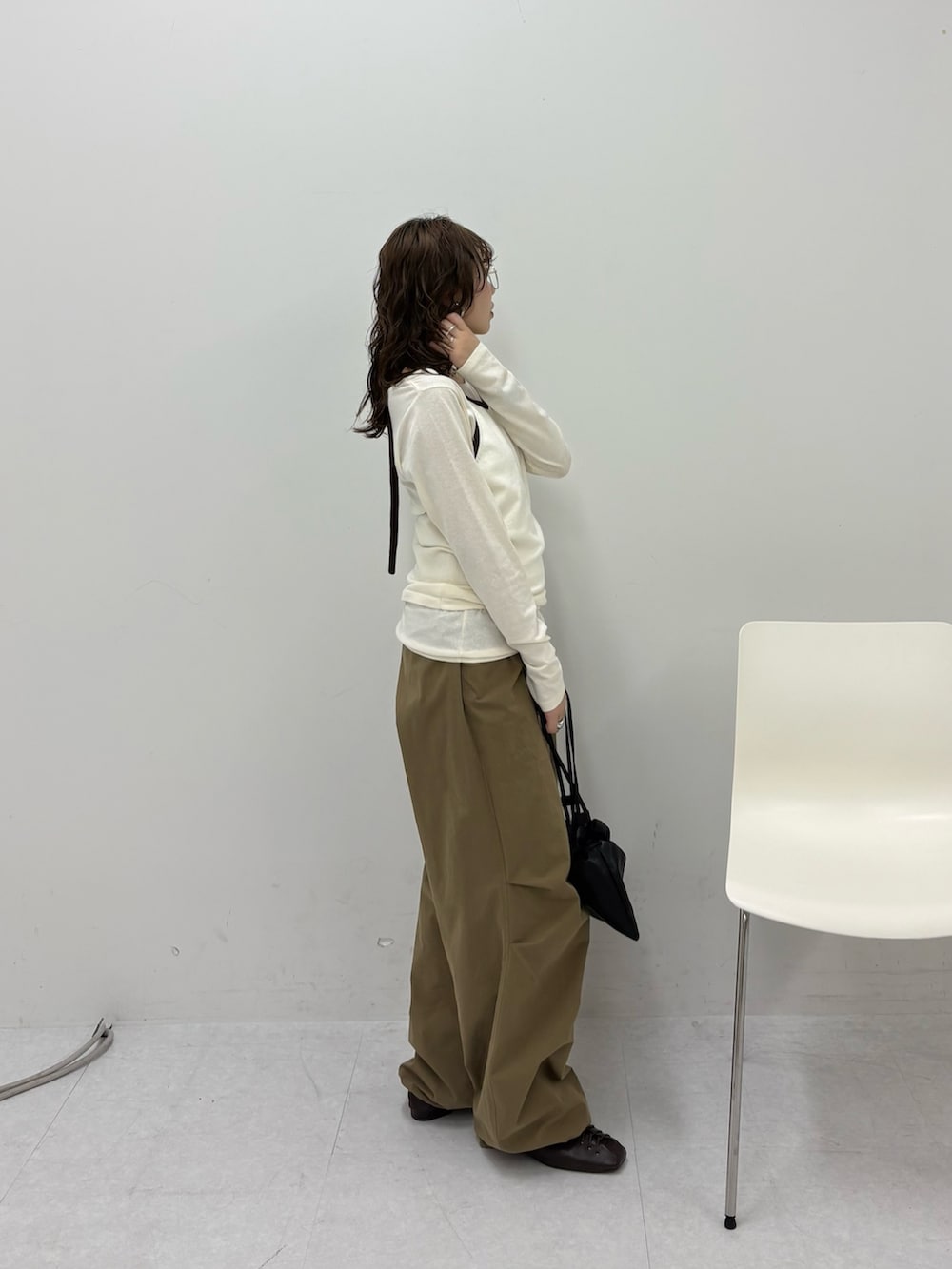 グリーン系のその他パンツ、ブラック系のその他シューズ、ブラック系のショルダーバッグを着用したレディースの冬コーディネートの2枚目の写真