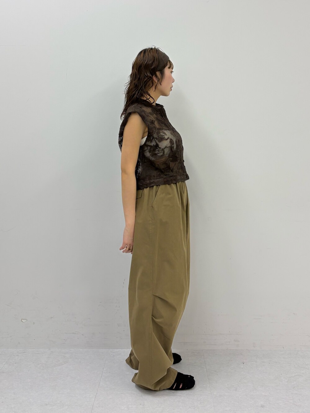 ブラウン系のシャツ/ブラウス、グリーン系のその他パンツ、ブラック系のサンダルを着用したレディースの春コーディネートの2枚目の写真