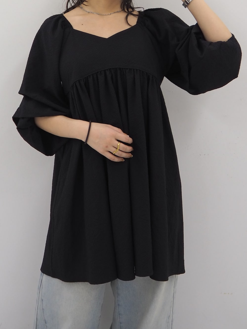 ブラック系のワンピース、ブルー系のデニムパンツ、ブラック系のその他シューズを着用したレディースの春コーディネートの4枚目の写真