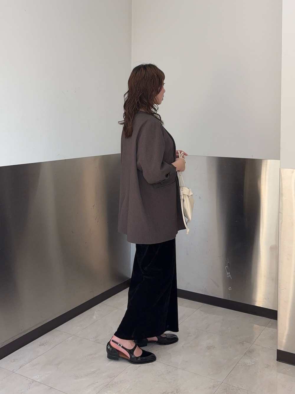 ブラウン系のノーカラージャケット、ブラック系のワンピース、ブラック系のローファーを着用したレディースの春コーディネートの2枚目の写真