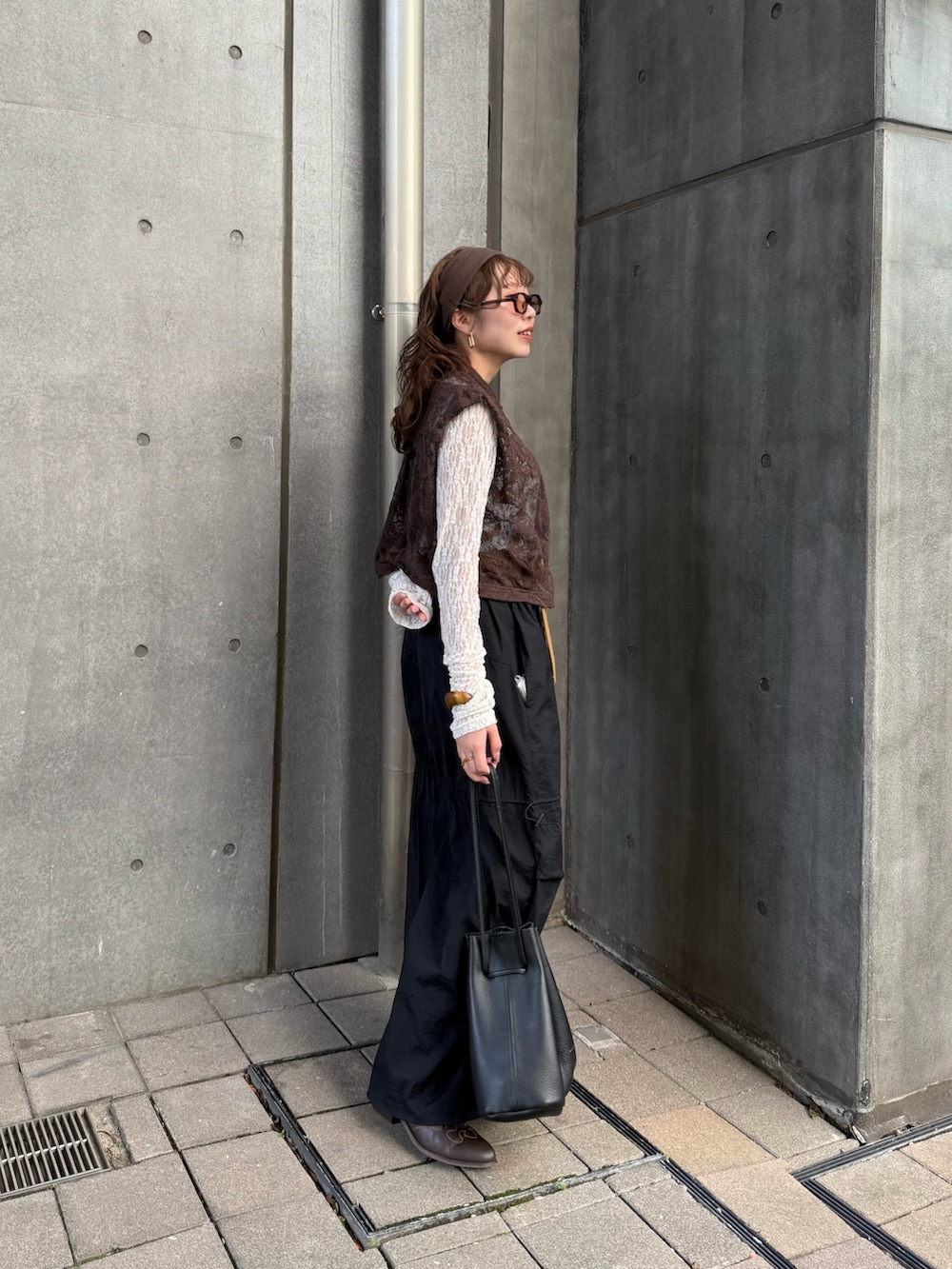 ブラウン系のシャツ/ブラウス、ブラック系のハンドバッグ、ホワイト系のTシャツ/カットソーを着用したレディースの春コーディネートの2枚目の写真