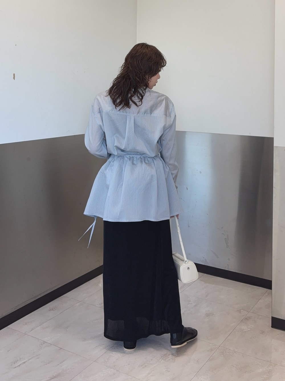 ブルー系のシャツ/ブラウス、ブラック系のスカート、ブラック系のパンプスを着用したレディースの冬コーディネートの3枚目の写真