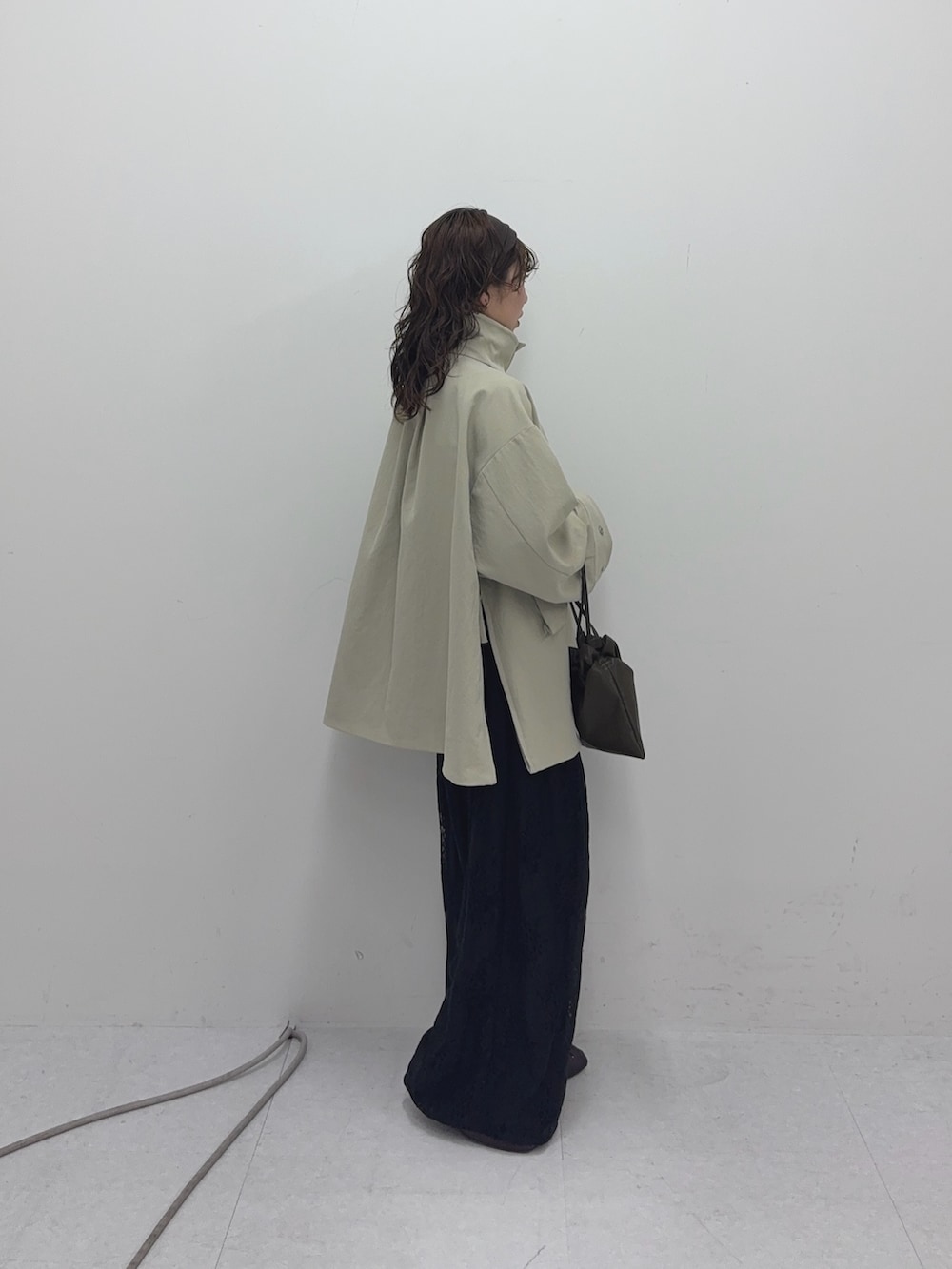 ベージュ系のその他アウター、ブラック系のその他パンツ、グリーン系のショルダーバッグを着用したレディースの冬コーディネートの2枚目の写真