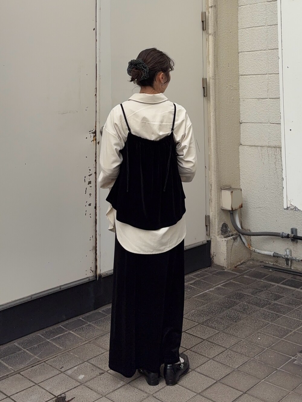 ブラック系のキャミソール、ブラック系のスカート、ホワイト系のシャツ/ブラウスを着用したレディースの秋コーディネートの4枚目の写真