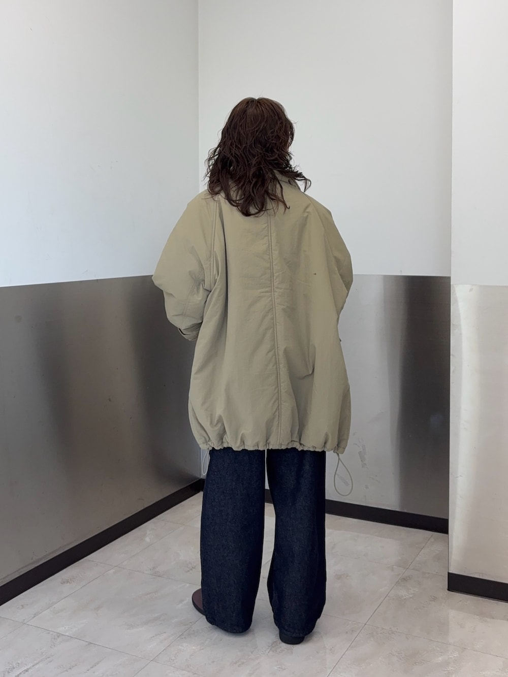 ブラウン系のTシャツ/カットソー、ブルー系のダウンジャケット/コート、ブルー系のデニムパンツを着用したレディースの冬コーディネートの3枚目の写真