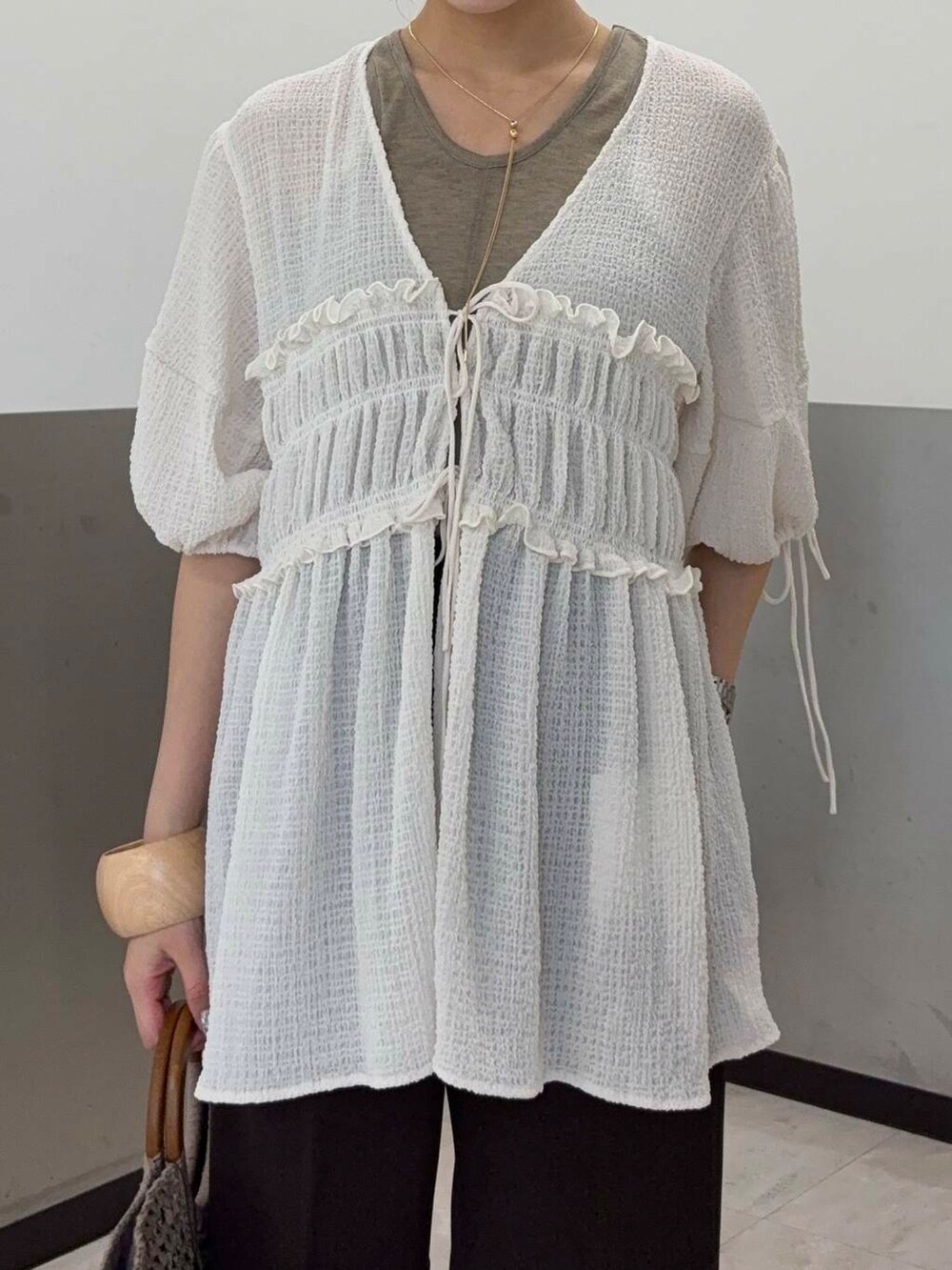 ベージュ系のタンクトップ、グレー系のトートバッグ、イエロー系のパンプスを着用したレディースの夏コーディネートの4枚目の写真