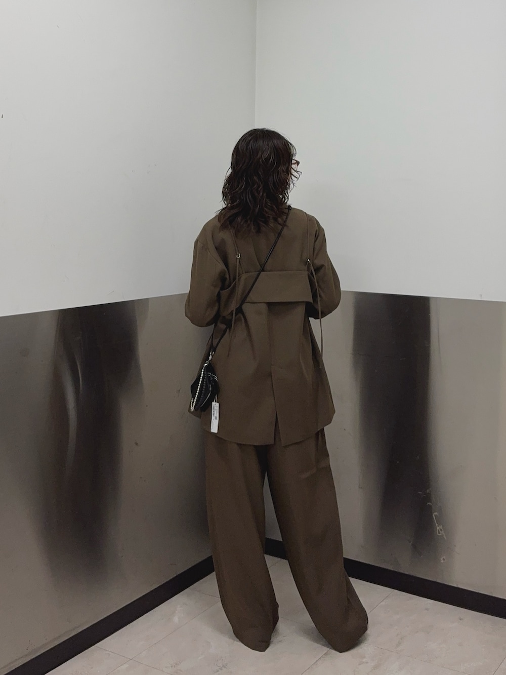 ブラウン系のその他アウター、ブラウン系のその他パンツ、ホワイト系のタンクトップを着用したレディースの秋コーディネートの3枚目の写真