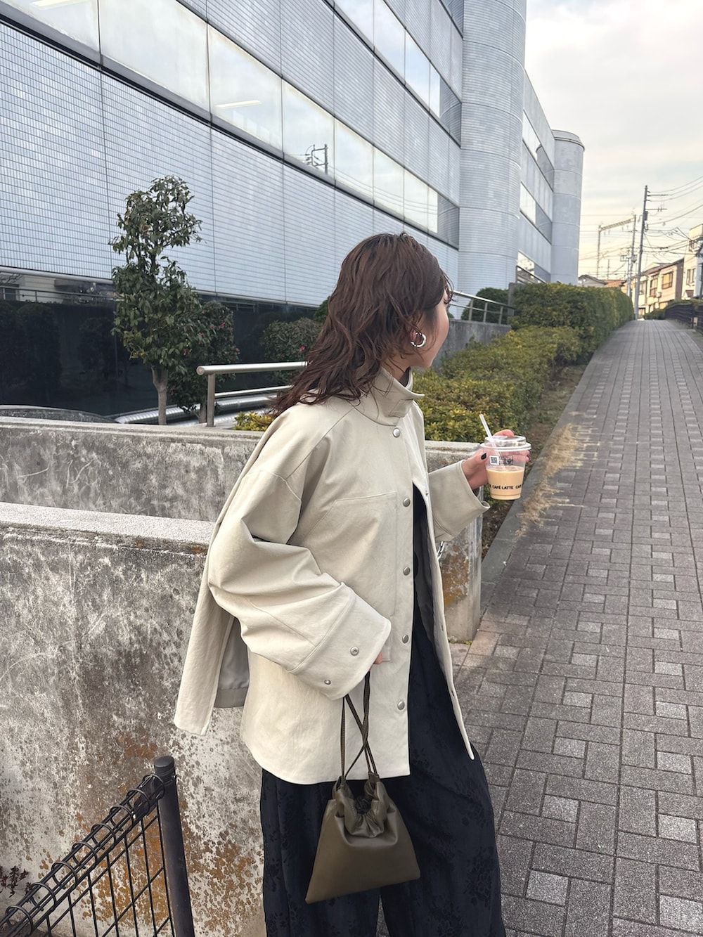 ベージュ系のその他アウター、ブラック系のその他パンツ、グリーン系のショルダーバッグを着用したレディースの冬コーディネートの4枚目の写真