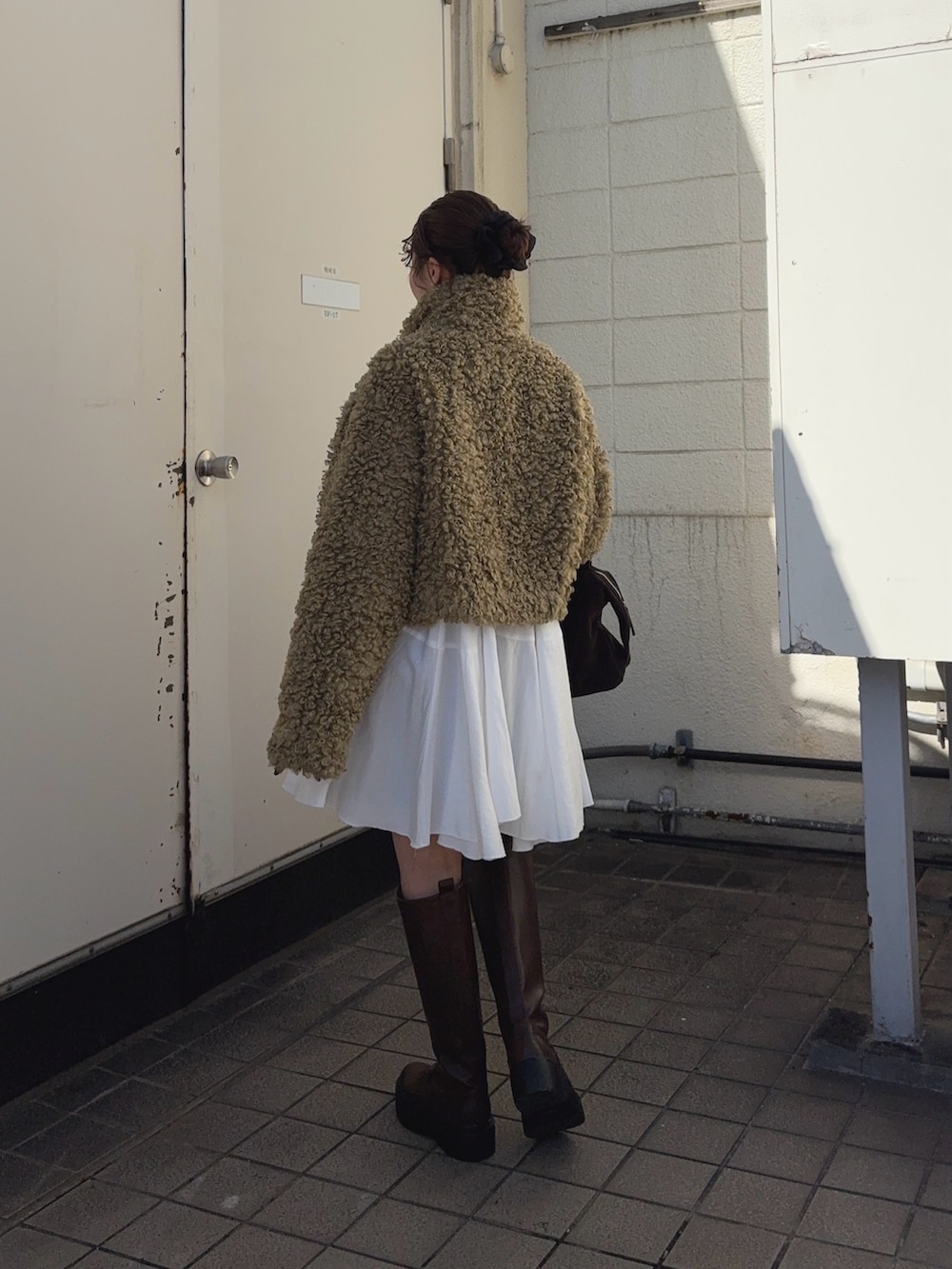 グリーン系のその他アウター、ホワイト系のワンピース、ブラック系のブーツを着用したレディースの冬コーディネートの3枚目の写真