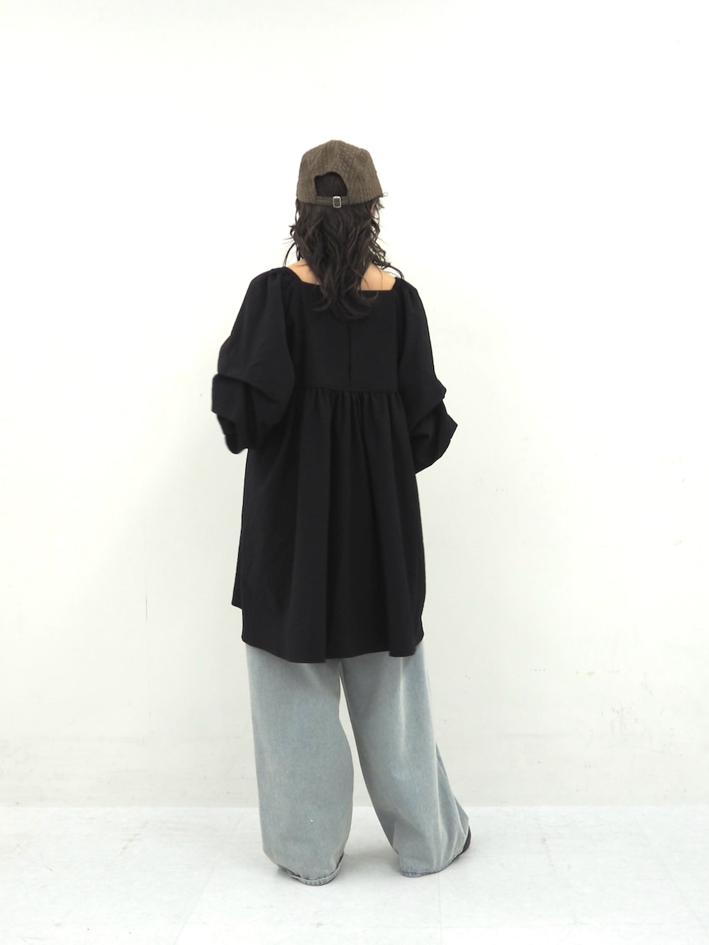 ブラック系のワンピース、ブルー系のデニムパンツ、ブラック系のその他シューズを着用したレディースの春コーディネートの2枚目の写真