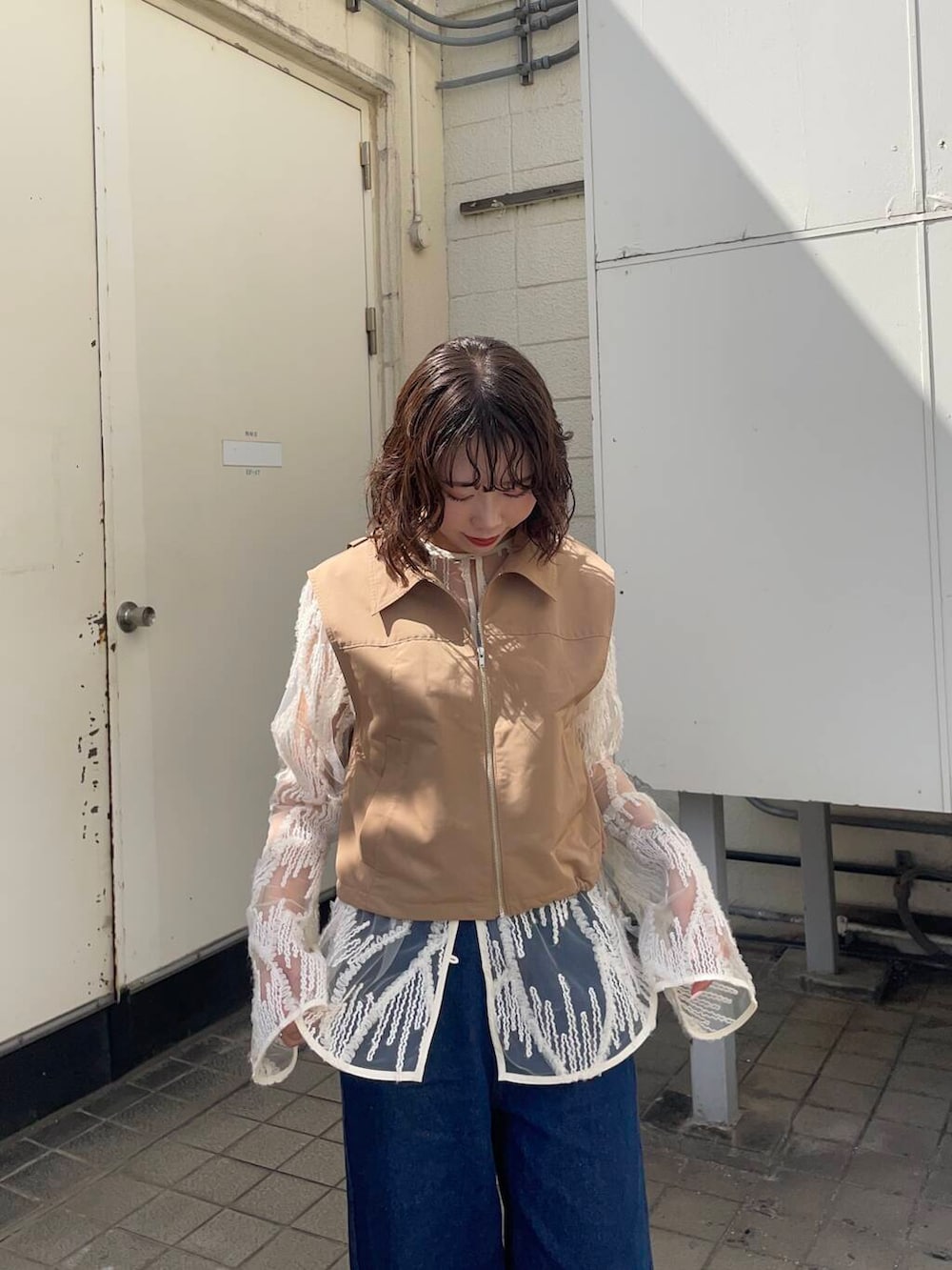 イエロー系のベスト、ブルー系のデニムパンツ、ホワイト系のシャツ/ブラウスを着用したレディースの春コーディネートの3枚目の写真