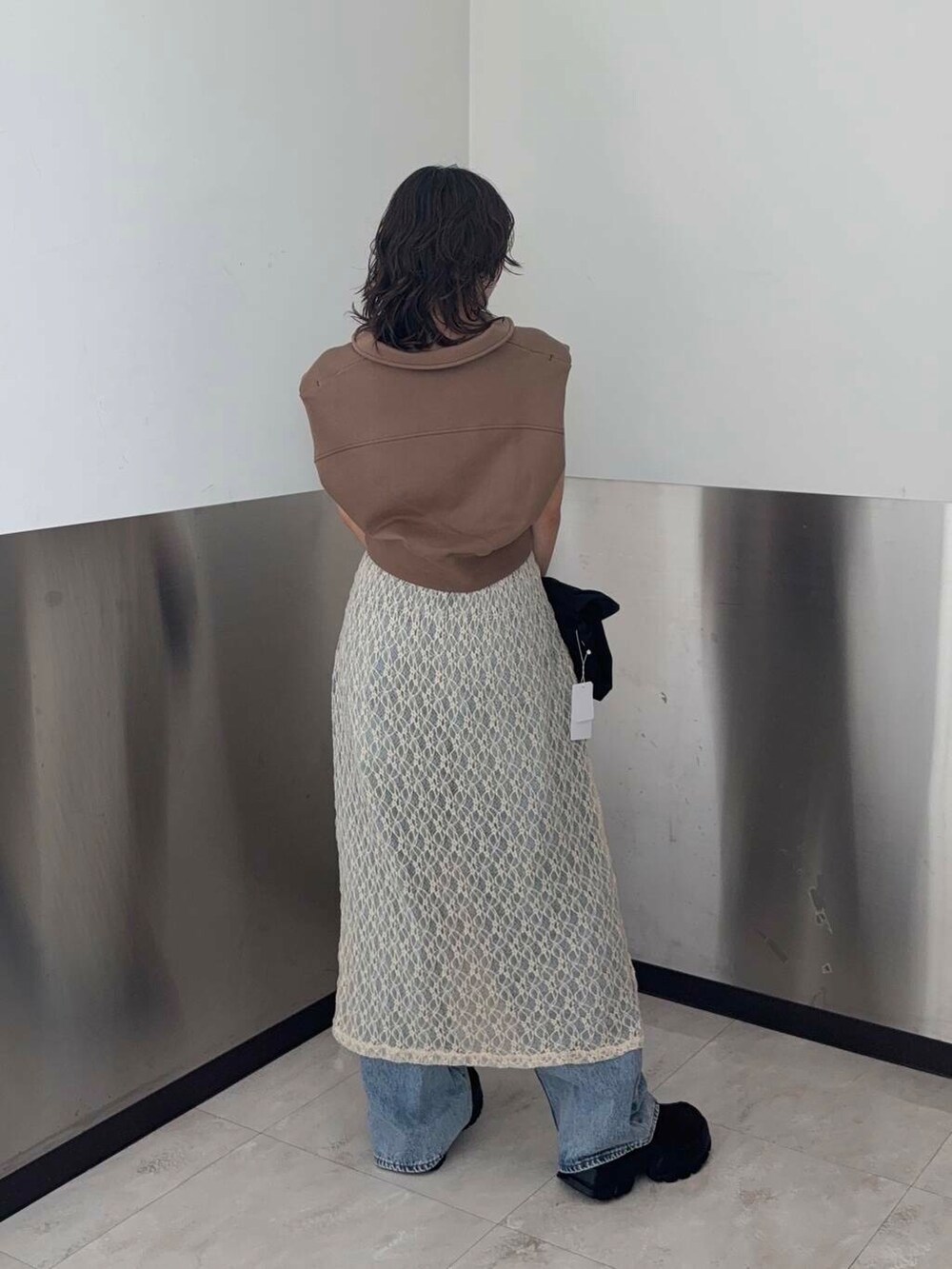 ブルー系のデニムパンツ、ブラウン系のスウェット、ブラック系のショルダーバッグを着用したレディースの夏コーディネートの3枚目の写真