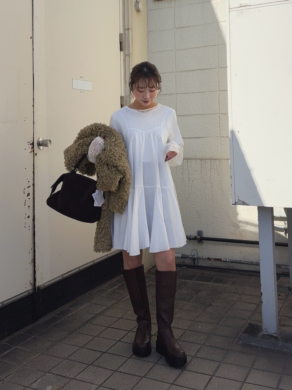 グリーン系のその他アウター、ホワイト系のワンピース、ブラック系のブーツを着用したレディースの冬コーディネートの4枚目の写真