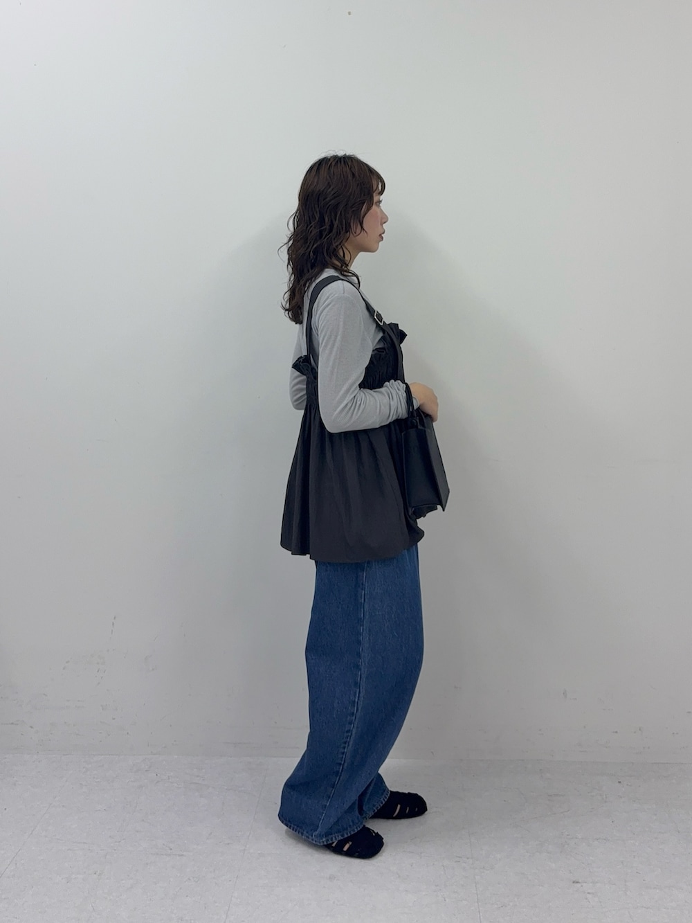 グレー系のその他トップス、ブルー系のデニムパンツ、ブラック系のサンダルを着用したレディースの春コーディネートの2枚目の写真