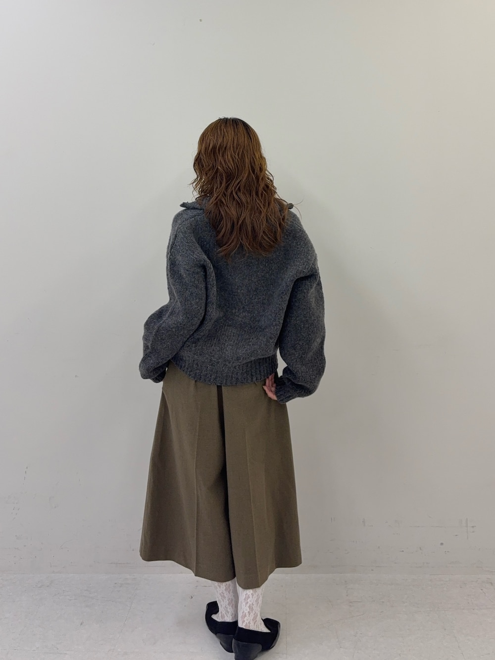 ブラック系のパンプス、グレー系のニット/セーターを着用したレディースの秋コーディネートの2枚目の写真