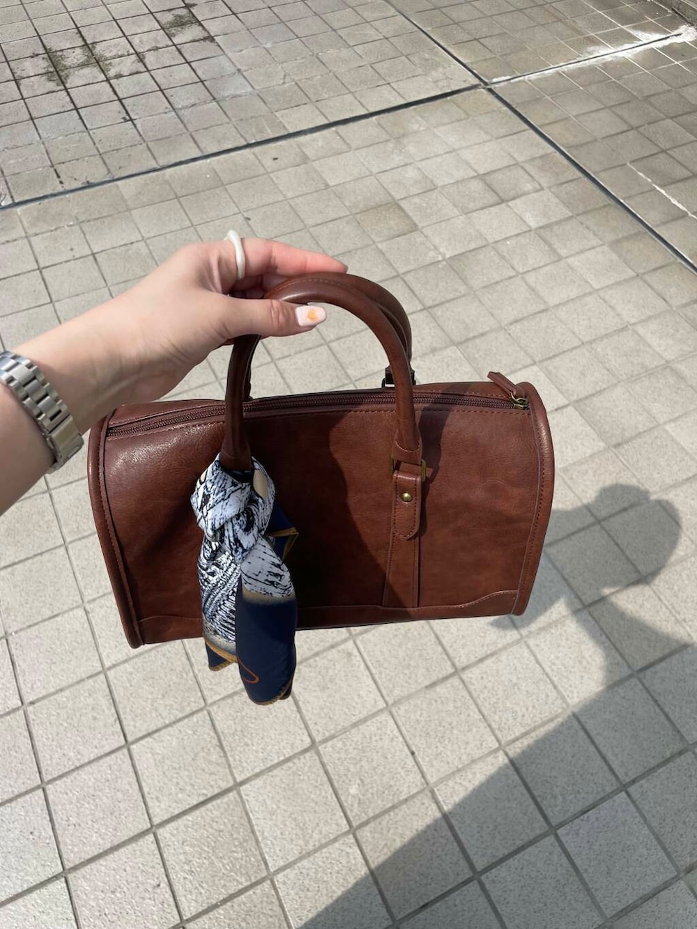 ブラウン系のボストンバッグ、グリーン系のスニーカー、ブルー系のワンピースを着用したレディースの春コーディネートの5枚目の写真