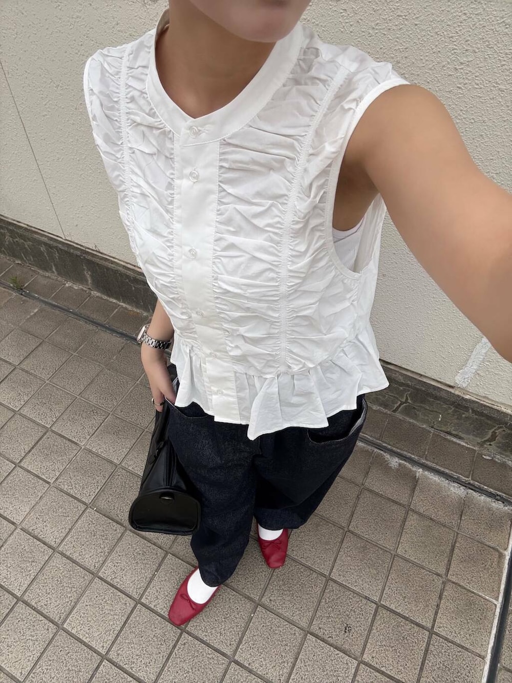 ブラック系のボストンバッグ、ブルー系のデニムパンツ、ホワイト系のシャツ/ブラウスを着用したレディースの春コーディネートの3枚目の写真