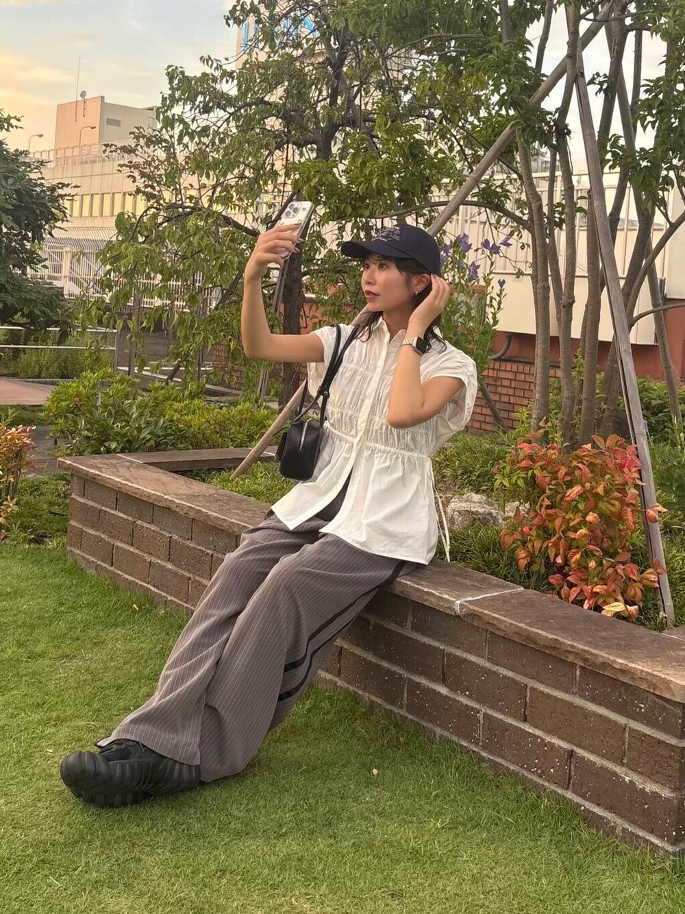 ブラック系のショルダーバッグ、グレー系のその他パンツ、ホワイト系のシャツ/ブラウスを着用したレディースの夏コーディネートの3枚目の写真