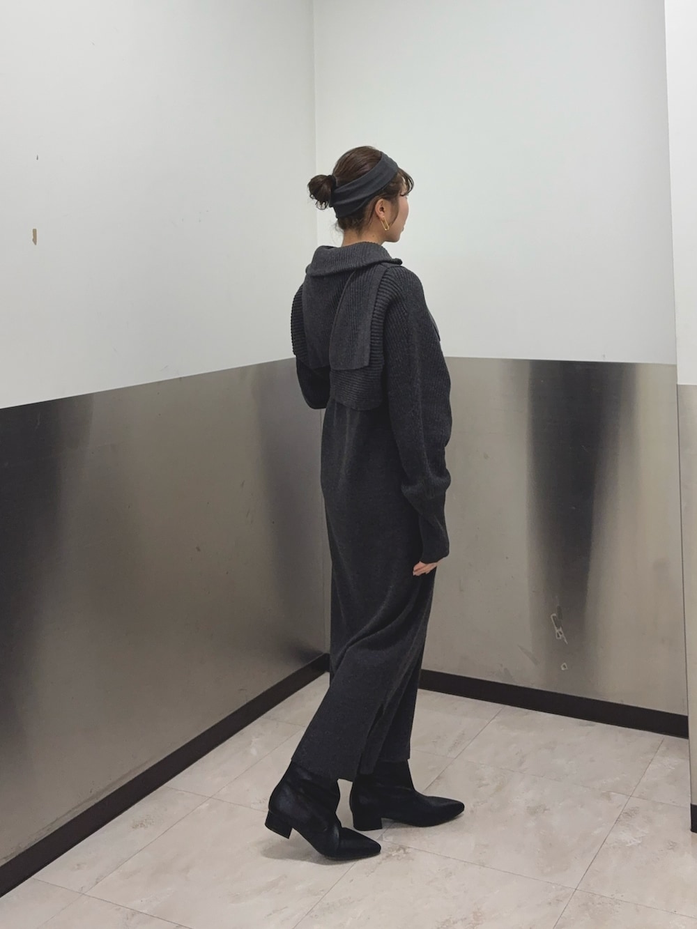 グレー系のワンピース、ブラック系のブーツ、ブラウン系のショルダーバッグを着用したレディースの冬コーディネートの2枚目の写真