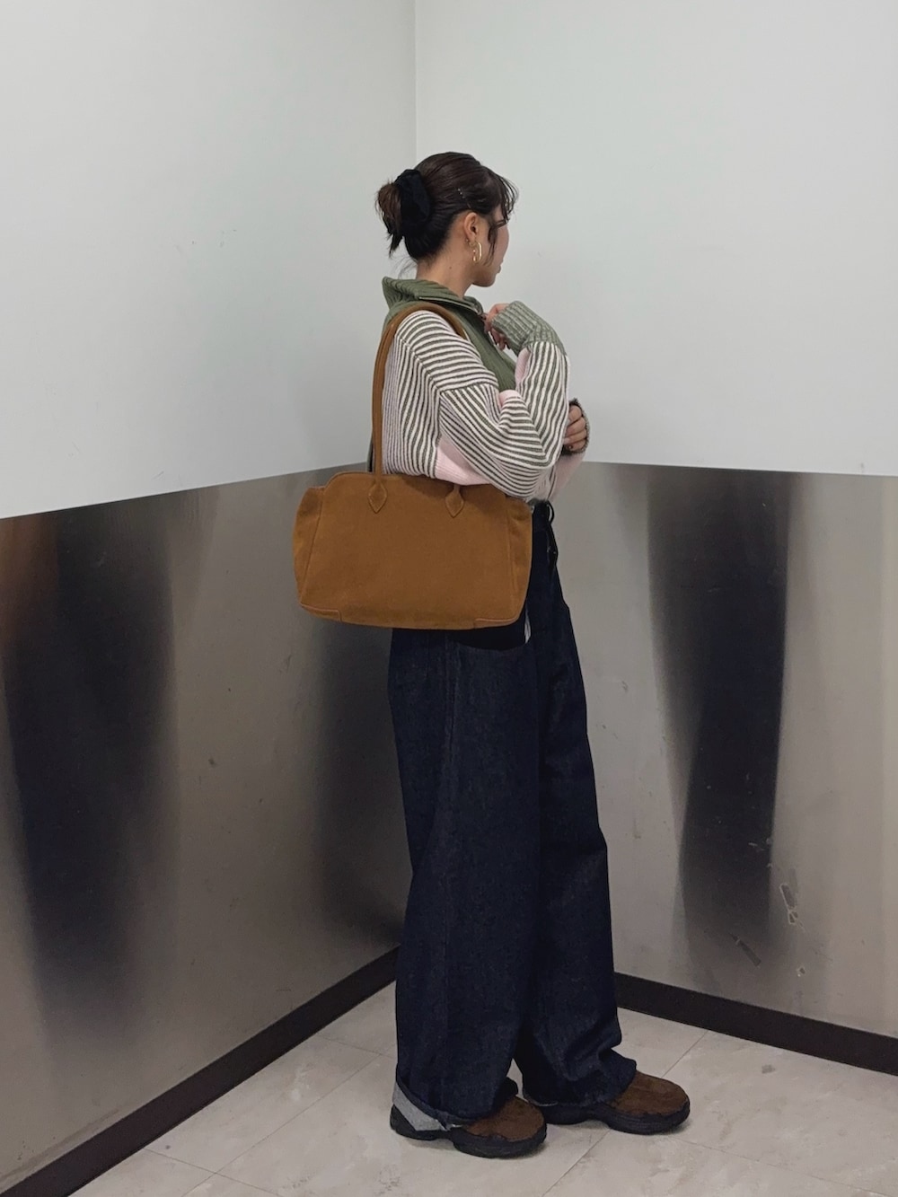 グリーン系のニット/セーター、ブルー系のデニムパンツ、ブラウン系のその他シューズを着用したレディースの秋コーディネートの3枚目の写真