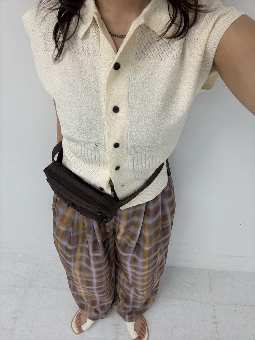 ホワイト系のニット/セーター、ブラウン系のその他パンツ、ブラウン系のボディバッグ/ウエストポーチを着用したレディースの春コーディネートの4枚目の写真