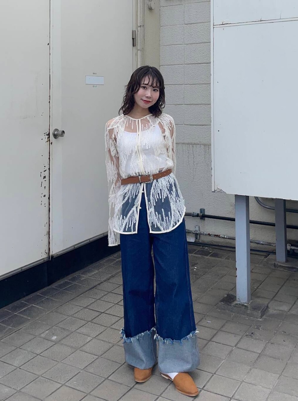 イエロー系のベスト、ブルー系のデニムパンツ、ホワイト系のシャツ/ブラウスを着用したレディースの春コーディネートの4枚目の写真