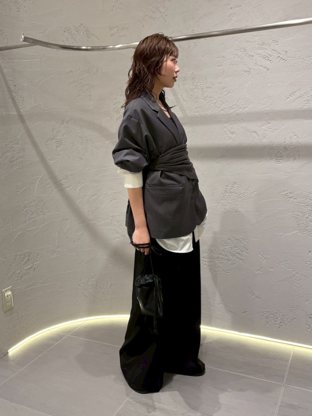 グレー系のその他アウター、ブラック系のその他パンツ、ブラック系のショルダーバッグを着用したレディースの春コーディネートの2枚目の写真