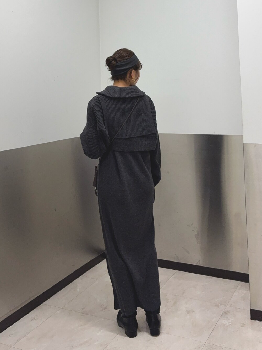 グレー系のワンピース、ブラック系のブーツ、ブラウン系のショルダーバッグを着用したレディースの冬コーディネートの3枚目の写真